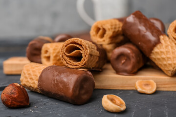 Delicious wafer rolls and hazelnuts on grunge background, closeup
