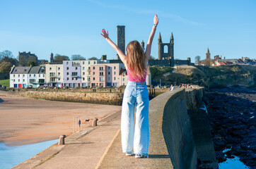 A girl walks along the promenade in the city of St. Andrews in the UK.