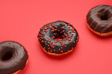 Delicious glazed donuts on red background, closeup