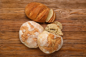 Loaves of different bread on wooden background