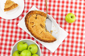 apple pie on a red checkered tablecloth top view