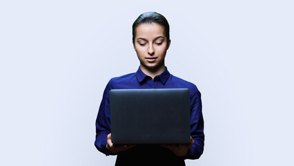 Teenage female student with laptop on white background