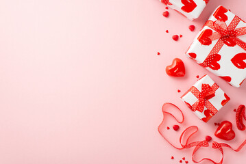 Valentine's Day concept. Top view photo of present boxes tulle ribbon heart shaped candles and sprinkles on isolated pastel pink background with empty space