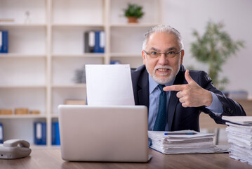 Old male employee working in the office