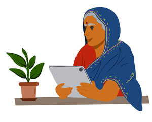 An elderly Indian woman sits at a table with a tablet. Flat vector illustration