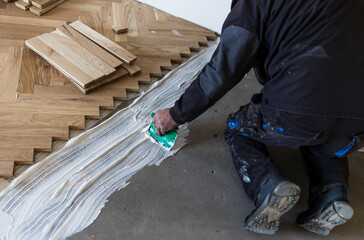 Man installing parquet at home