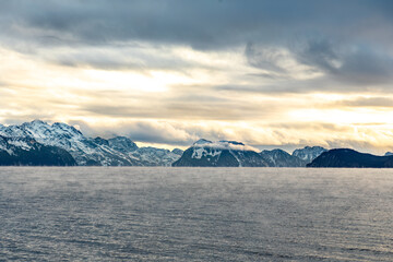 Steam rises from the open water over Resurrection Bay in Seward Alaska on a frigid cold winter day