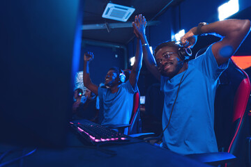 African American support Team professional gamer playing winning tournaments online games computer