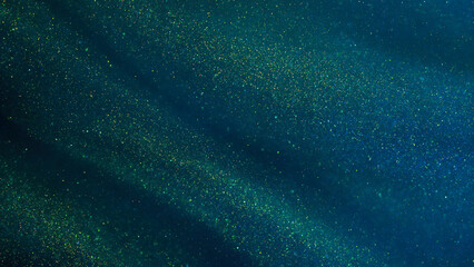 Abstract galaxy background. Golden glitter particles on a dark green background with blue hues....