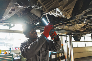 Skilled mechanic replacing a car's clutch using a torch in an auto repair shop. High-quality photo
