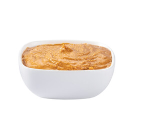 Creamy peanut butter in small bowl isolated on white background