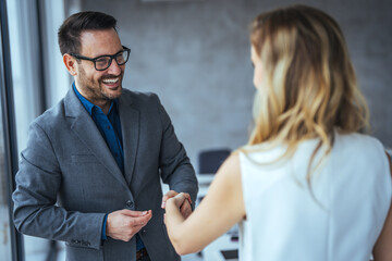 Shot of two businesspeople shaking hands in an office. Smiling business people handshake after successful negotiation. Handshake for the new agreement.