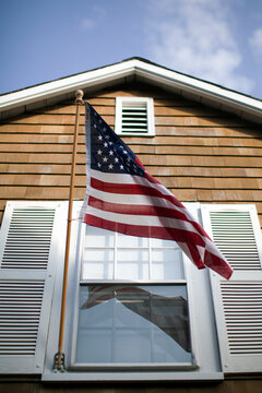 American flag blows in the wind on a fa&Atilde;&sect;ade of a building in Rockport, Massachusetts.