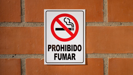 No smoke sign on brick wall in Spanish