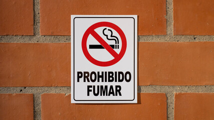 No smoke sign on brick wall in Spanish