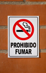No smoke sign on brick wall in Spanish