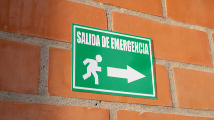 Green emergency exit sign in Spanish