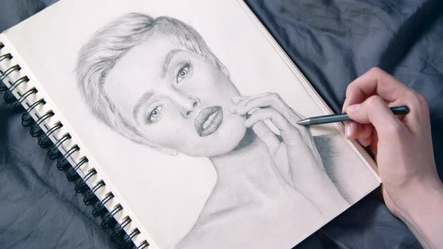 Footage of a female artist drawing a portrait of a woman. Close-up of portraying a beautiful young girl. High quality 4k footage