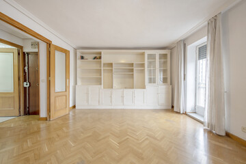 Living room of an empty house with French oak parquet floors and beautiful custom built white...