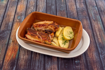 Roast beef brisket with baked potatoes in a clay pot