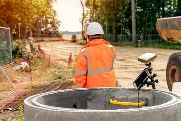 Surveyor site engineer with total positioning station on the construction site of the new road...