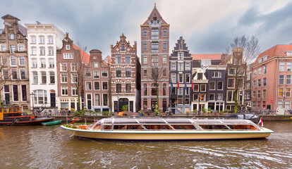 Beautiful old houses on the city embankment of Amsterdam on a winter day.