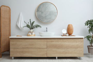 Modern bathroom interior with stylish mirror, eucalyptus branches and vessel sink