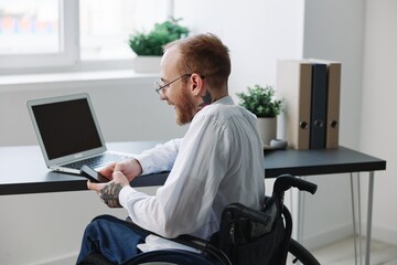 A man wheelchair, businessman in the office working laptop, working online, social networks...