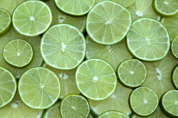 Fototapeta na wymiar Fresh lime slices as background, top view