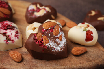 Tasty chocolate heart shaped candies with nuts, closeup