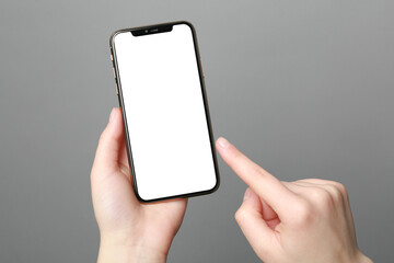 Woman using smartphone on grey background, closeup. Mockup for design