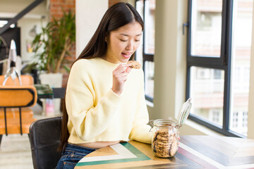 asian pretty woman eating cookies at cool living room