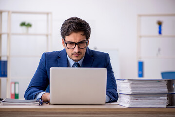 Young businessman employee and too much work in the office