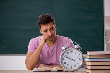 Young male student preparing for exams in time management concep