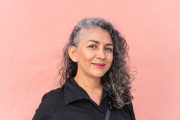 Gray-haired woman posing in the city.