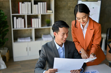 Professional Asian businessman working with a gorgeous female financial manager