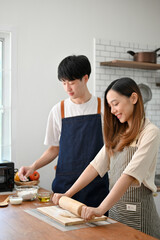 Beautiful Asian female enjoy baking pastry with her boyfriend in the kitchen, making dough