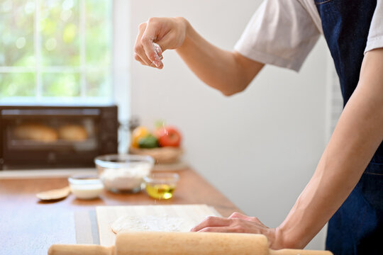 Close-up image, A male baker making dough on the kitchen table, preparing raw dough