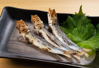 Grilled urume sardine placed on the table. A side dish of sake.