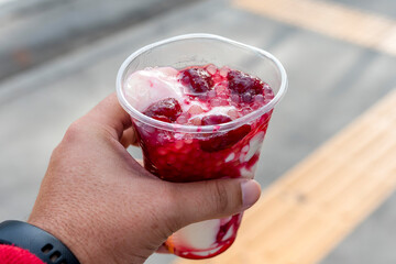 A customer holding Strawberry Taho, a popular delicacy in Baguio. A soybean curd with strawberry...