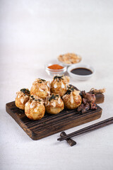 Takoyaki is Japanese Street Food containing with octopus, sausage or cheese. garnish with seaweed and katsuobushi