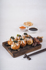 Takoyaki is Japanese Street Food containing with octopus, sausage or cheese. garnish with seaweed and katsuobushi