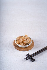 katsuobushi is japanese food in white bowl on white concrete. Protein food.