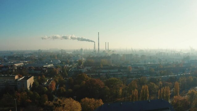 Aerial view of the city in a small haze and Chimneys releasing smoke or steam from the heat of the power plant. Gray steam comes out of tall chimneys in the city center. Gdansk. Poland. 