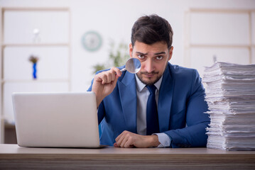 Young male employee and too much work in the office