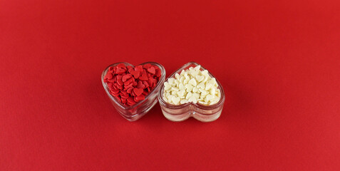 Sugar decorations in the form of hearts on a red background for Valentine's Day.
