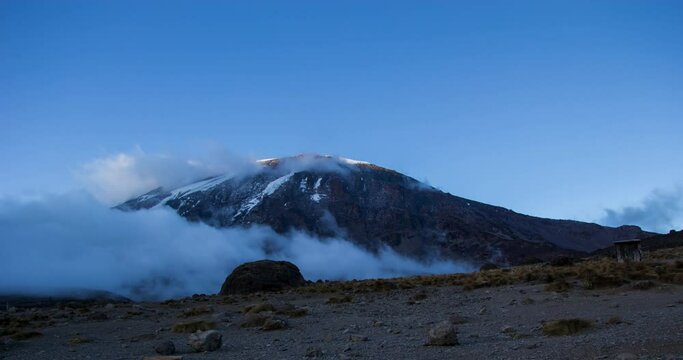 Clouds building around the summit of Mount Kilimanjaro while the sun sets