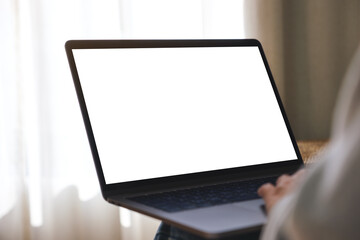 Mockup image of a woman working and typing on laptop computer with blank screen at home