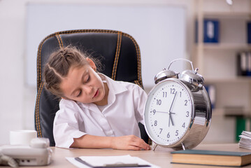 Small girl sitting in the classroom in time management concept