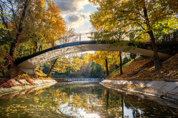 Picturesque bridge across the autumn lake in Almaty Gorky Park, Kazakhstan.